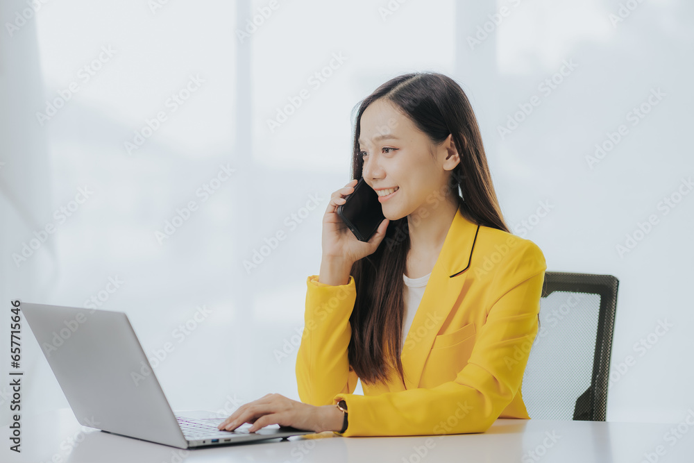 Portrait of Asian businesswoman using laptop and smart phone to do finance, mathematics on office table, taxes, reports, accounting, statistics and analytical research concepts. Portrait of Asian businesswoman using laptop and smart phone to do finance, mathematics on office table, taxes, reports, accounting, statistics and analytical research concepts.
