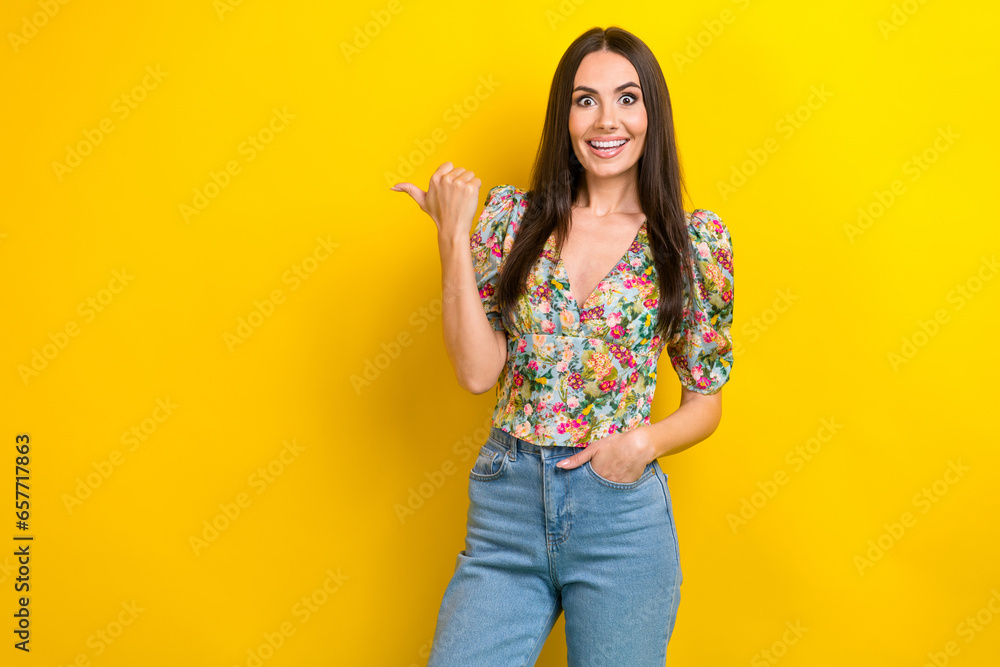 Photo of cheerful adorable girl wear trendy clothes thumb direct empty space special wow proposition isolated on yellow color background Photo of cheerful adorable girl wear trendy clothes thumb direct empty space special wow proposition isolated on yellow color background