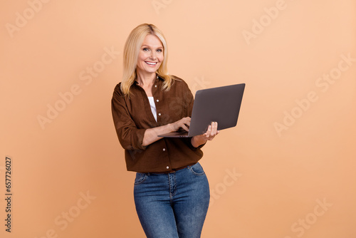 Photo of young business leader woman blonde hair wear stylish clothes chatting netbook messenger isolated on beige color background