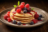 a stack of pancakes with berries and syrup on a plate