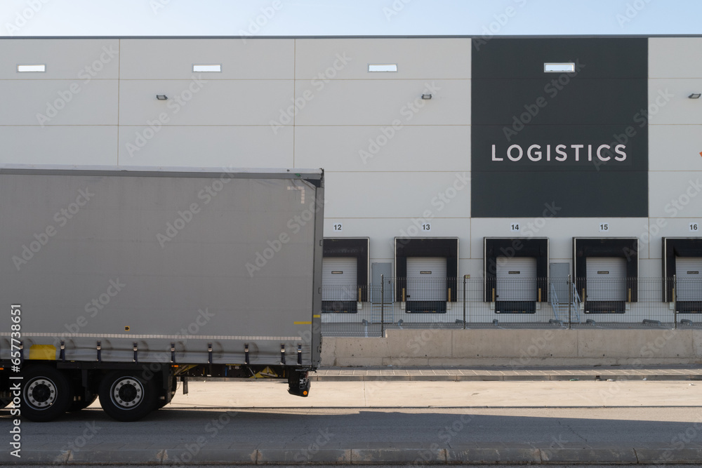 Vista de un camión trailer esperando para entrar al muelle de una empresa logistica de distribucion de productos. - obrazy, fototapety, plakaty 