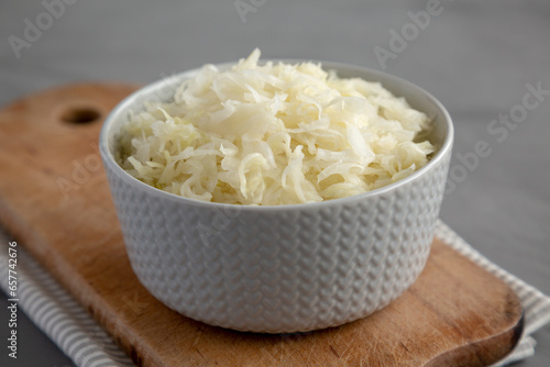 Homemade German Sauerkraut in a Bowl on a gray background, side view.