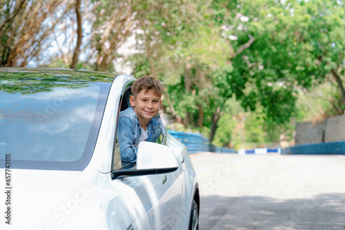 Excited and happy young little boy with smile on his face show up on car window while driving, playful and cheerful expression while on the road trip traveling by car during summertime. Perpetual