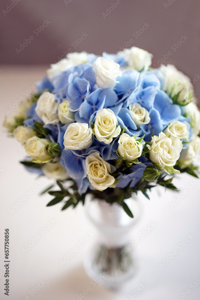 A beautiful bouquet of white and blue roses in a vase on the table. A beautiful bouquet of white and blue roses in a vase on the table.
