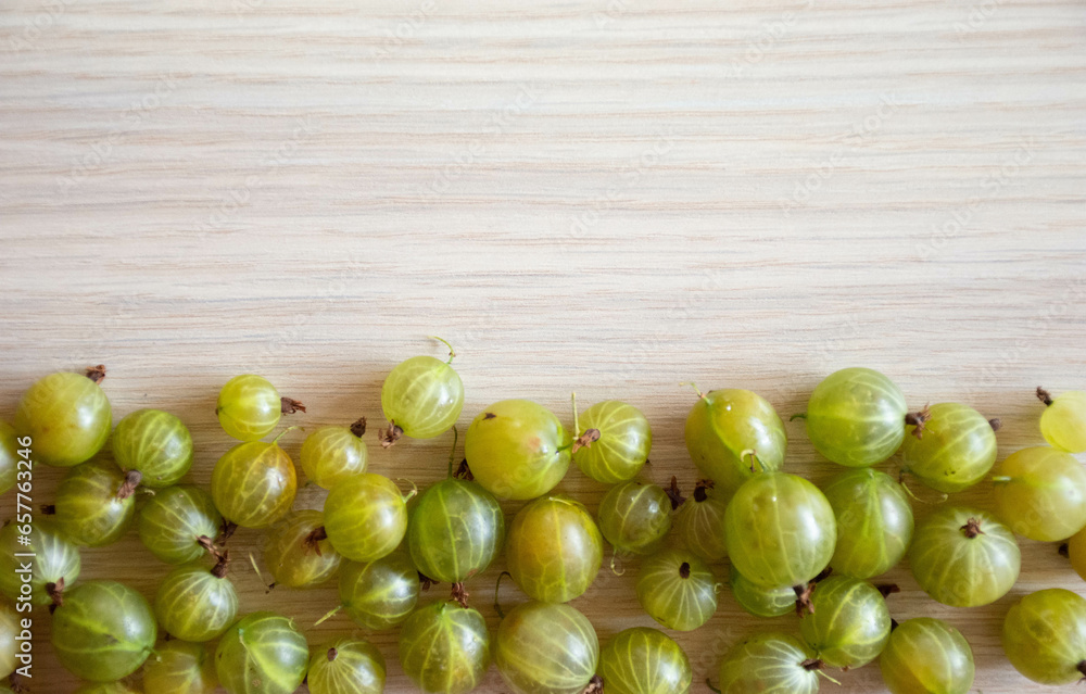 Gooseberries on a wood background .Healthy fruits on light wood background Gooseberries on a wood background .Healthy fruits on light wood background
