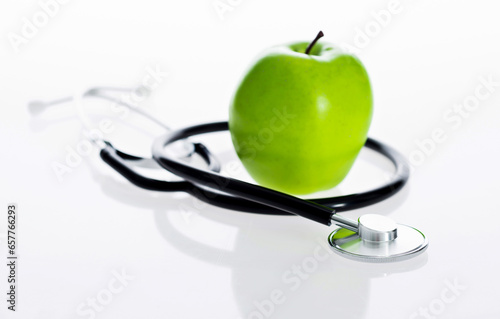 Green apple and stethoscope isolated on white background