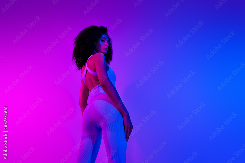 Rear back photo of serious sportswoman wear top elastic leggings booty ass look you isolated over neon light colorful filter background