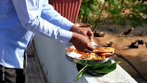 Indian religious man placed food on a leaf and invited the crow bird to eat. Hindu Pitru Paksha or Shraddha festival. photo