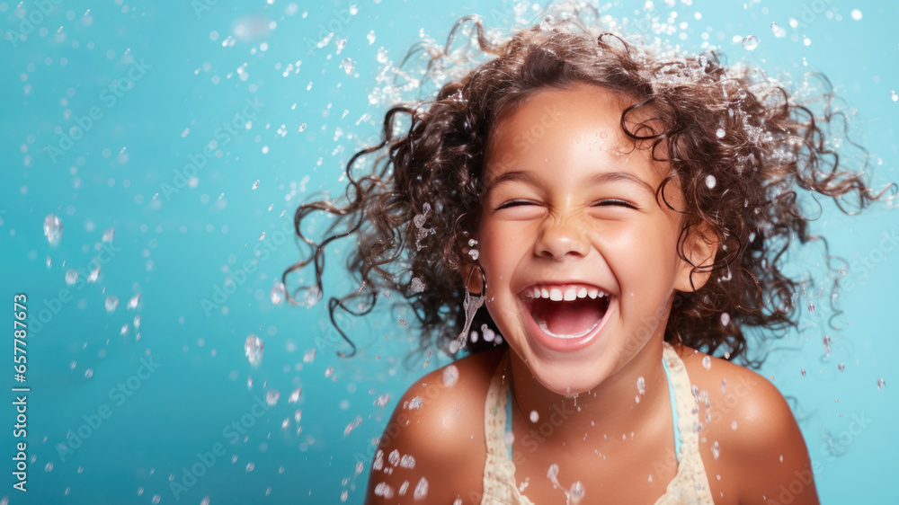 Smiling curly brunette girl wearing swimsuit playing water splash