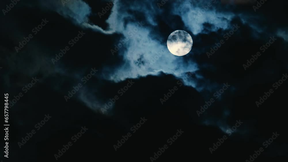 Full moon on amidst clouds in the black night sky. Epic video like a horror film. Time lapse. Close-up. Full moon time of werewolves Full moon on amidst clouds in the black night sky. Epic video like a horror film. Time lapse. Close-up. Full moon time of werewolves