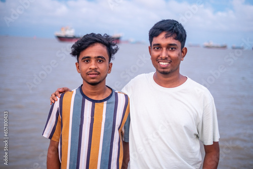 Portrait of south asian young boys standing in front of a river wearing casual t shirt 