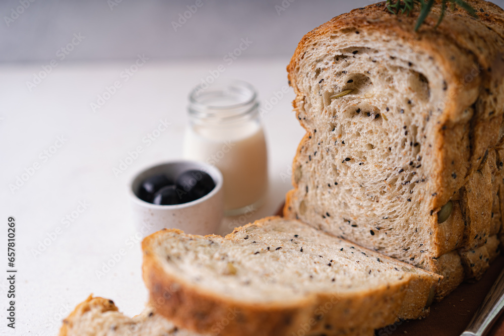 Fresh Sliced Homemade Wholegrain Wheat Bread whit olive oil on white rustic background. Artisan Sourdough