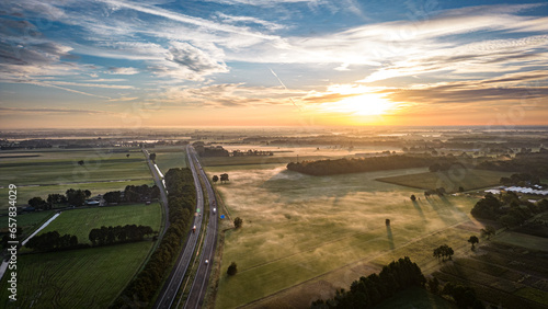 Sunrise over a field and highway
