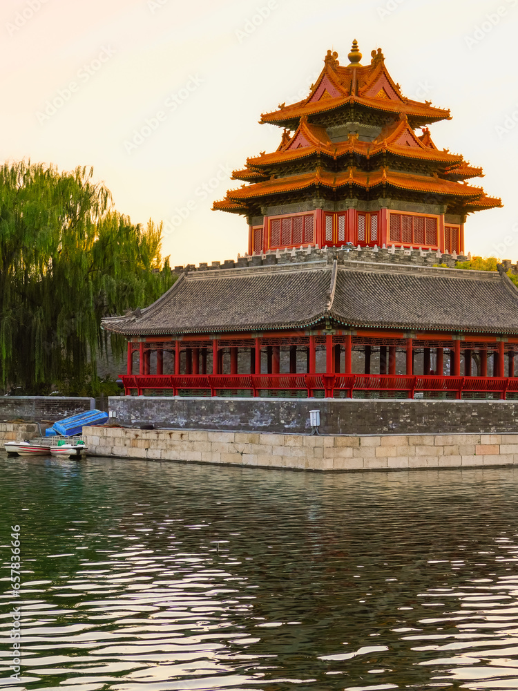 View of the Forbidden City with the reflection on the moat at sunset in Beijing, China.