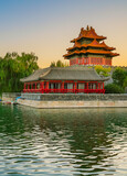 View of the Forbidden City with the reflection on the moat at sunset in Beijing, China.