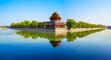 View of the Forbidden City with the reflection on the moat on a sunny day in Beijing, China.