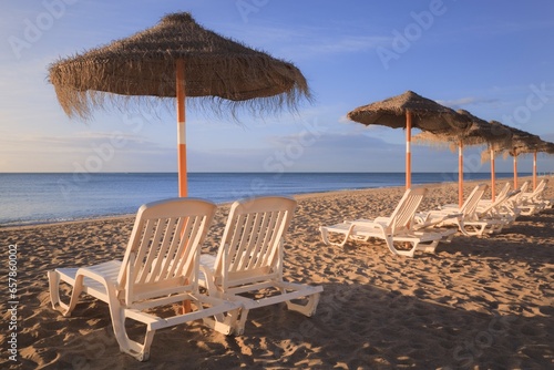 Sun Umbrellas And Beach Chairs On A Beach In Costa Del Sol; Torremolinos, Malaga, Andalusia, Spain photo
