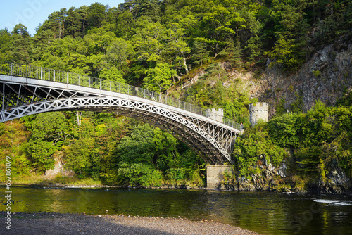 Craigellachie Bridge over the river Spey in the Speyside in Scotland. It was designed by Thomas Telford and is a cast iron bridge. photo