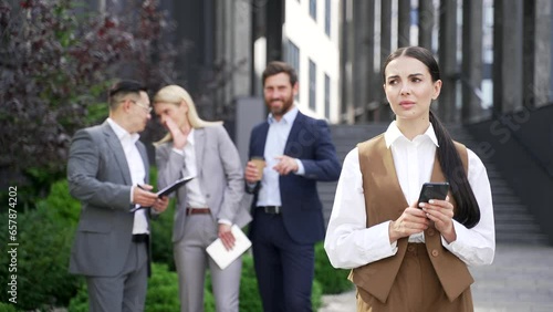 Coworkers employees group man and woman Whispering Behind Back. three colleagues are gossiping at background behind young specialist worker workmate bullying problem at work place in office outside
