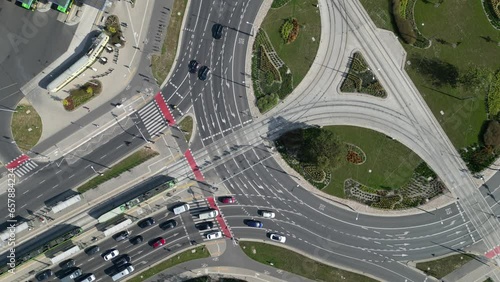 Aerial top down footage of traffic on big roundabout, driving cars and tramways