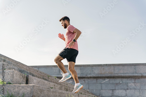 A healthy person trains alone in fitness clothes. Physical activity cardio lifting training for the body. Sports running shoes. Jogging male runner.