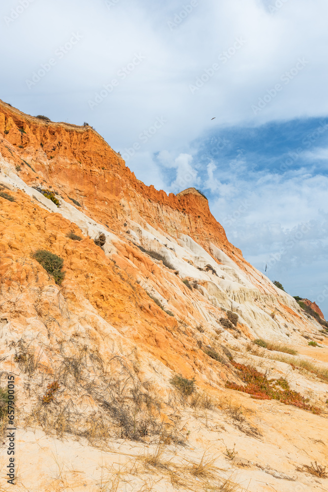 Red cliffs on sandy beach in Algrave, Portugal at sunny day