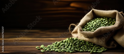 Green coffee beans in burlap bag on wooden surface center of frame photo