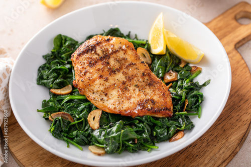 Bild auf Leinwand Grilled chicken breast with sauteed garlic spinach, healthy lunch idea