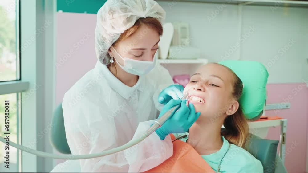 Dentist makes hygienic clean brush teeth in dentistry for teen girl. Dentist makes hygienic clean brush teeth in dentistry for teen girl.