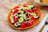 Delicious summer salad of cucumbers and tomatoes on a plate