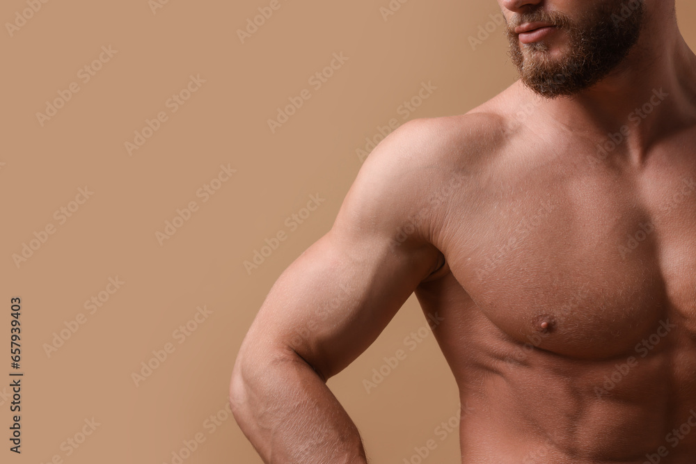Muscular man on beige background, closeup and space for text. Sexy body