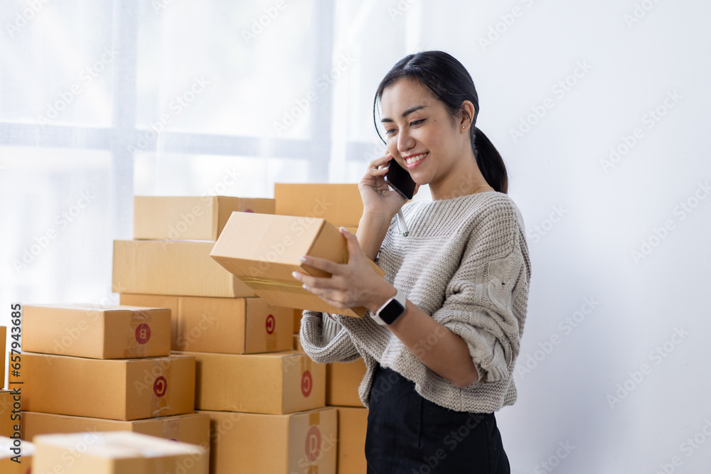 Starting small businesses SME owners asian female entrepreneurs call phone on receipt box and check online orders to prepare to pack the boxes, sell to customers, SME business ideas online. Starting small businesses SME owners asian female entrepreneurs call phone on receipt box and check online orders to prepare to pack the boxes, sell to customers, SME business ideas online.