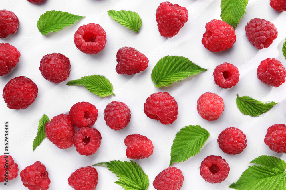 Tasty ripe raspberries and green leaves on white background, flat lay - obrazy, fototapety, plakaty 