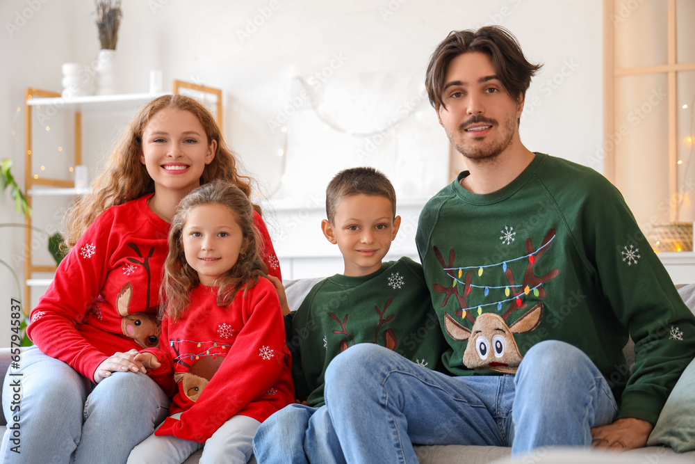 Happy family in warm sweaters sitting on sofa at home