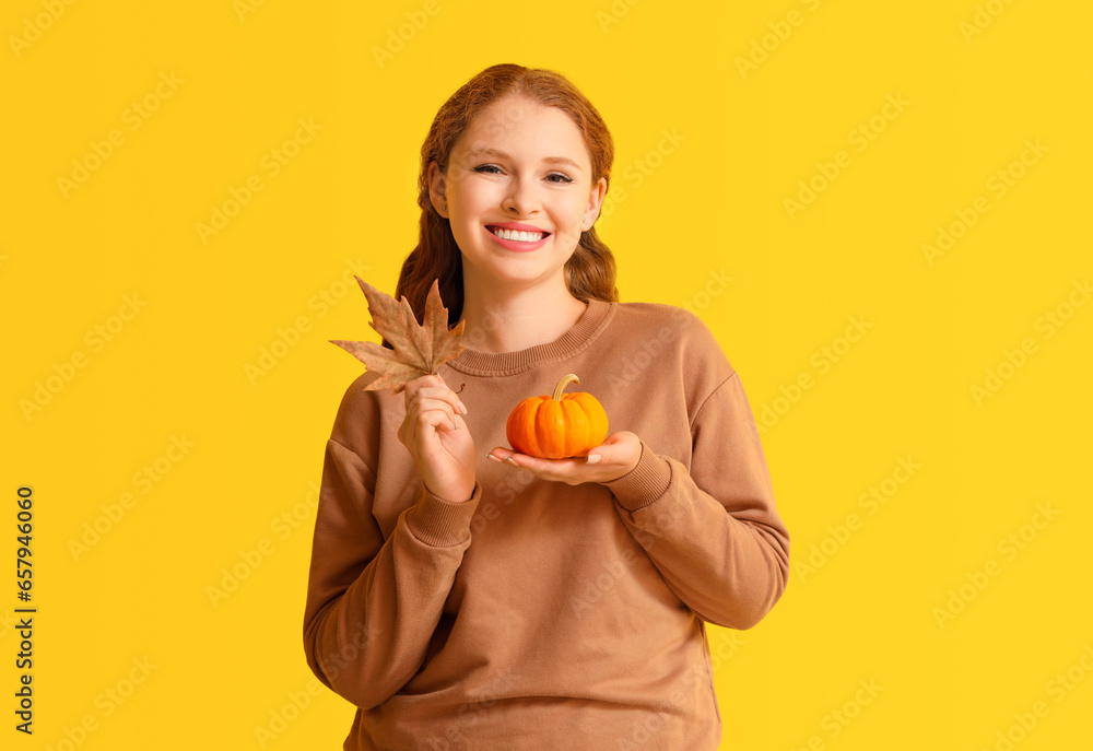 Young woman with pumpkin on yellow background Young woman with pumpkin on yellow background