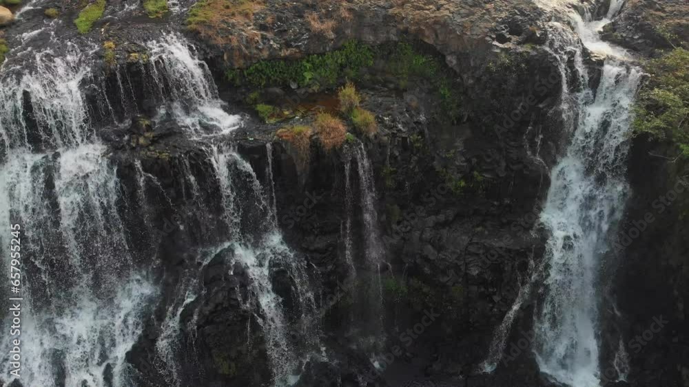 Reveal shot of famous Tad Gneuang Waterfall at Laos during sunset, aerial Reveal shot of famous Tad Gneuang Waterfall at Laos during sunset, aerial