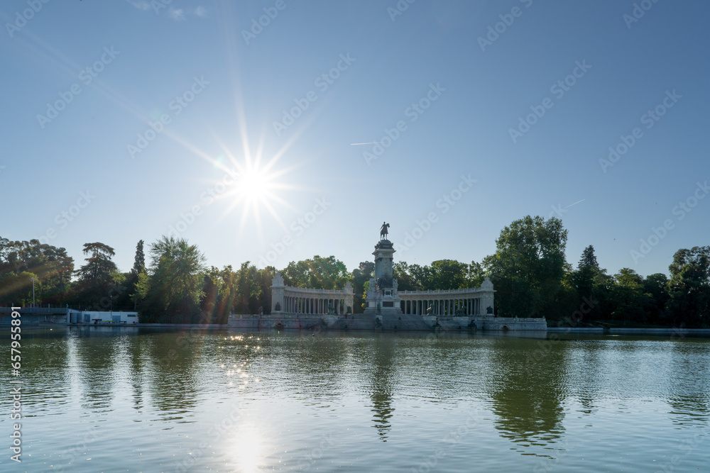 Monument of Alfonso XII with the sun in the background in Parque del Retiro, Madrid, Spain