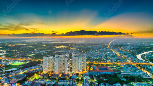 Aerial view of Saigon cityscape at evening with sunset sky in Southern Vietnam. Urban development texture, transport infrastructure and green parks photo