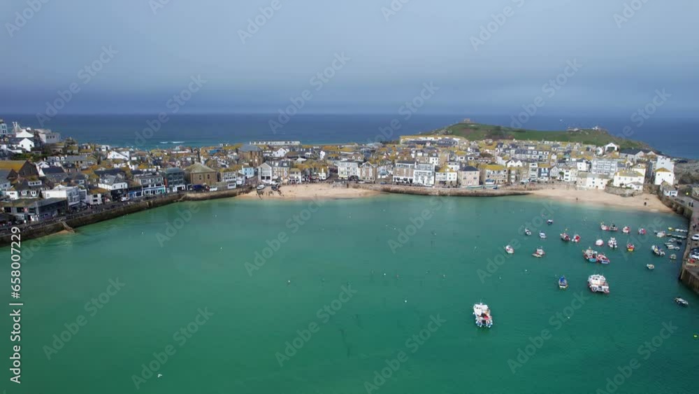Scenic Views Overlooking St Ives Coastal Town Harbor with Turquoise Waters and Boats on a Beautiful Summers Day in the Southwest of England with an Aerial Drone Shot. Scenic Views Overlooking St Ives Coastal Town Harbor with Turquoise Waters and Boats on a Beautiful Summers Day in the Southwest of England with an Aerial Drone Shot.