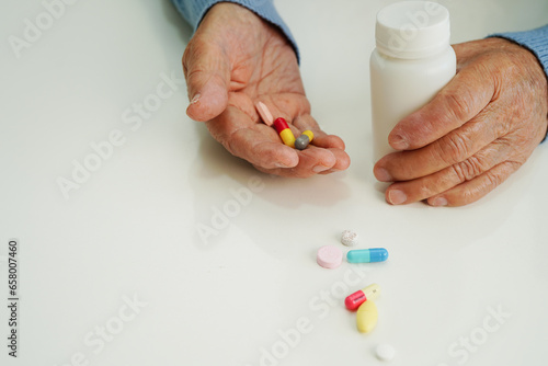 Asian elderly woman holding pill drug in hand, strong healthy medical concept.