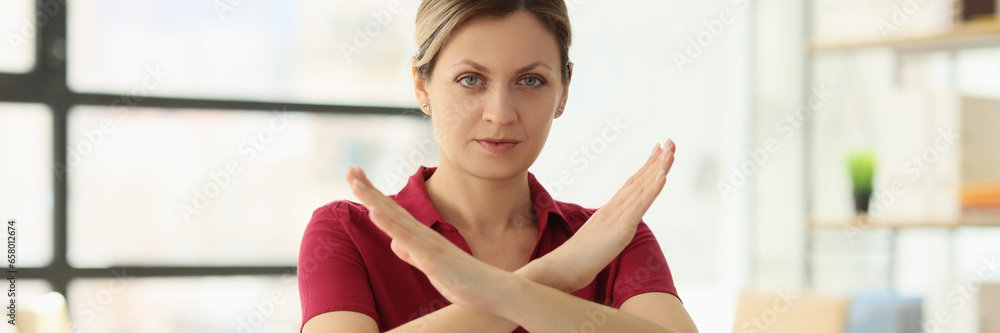 Woman manager shows Stop gesture at desk in company office