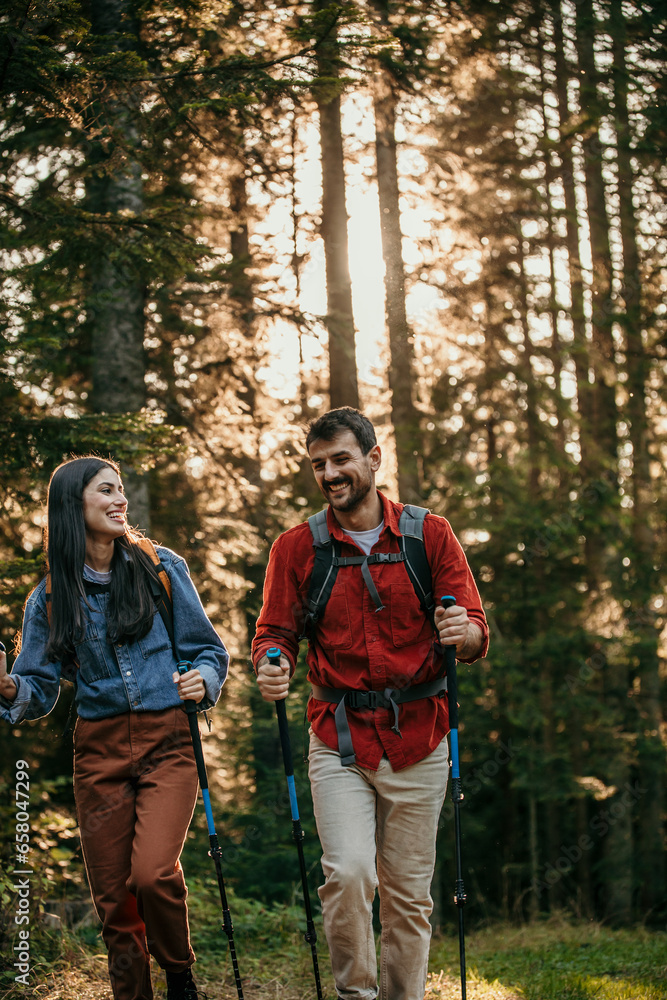 A couple clad in professional hiking gear makes their way through a mystical forest in pursuit of outdoor adventure A couple clad in professional hiking gear makes their way through a mystical forest in pursuit of outdoor adventure