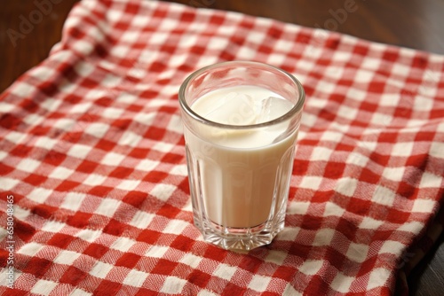 a glass of cream soda on a checkered cloth