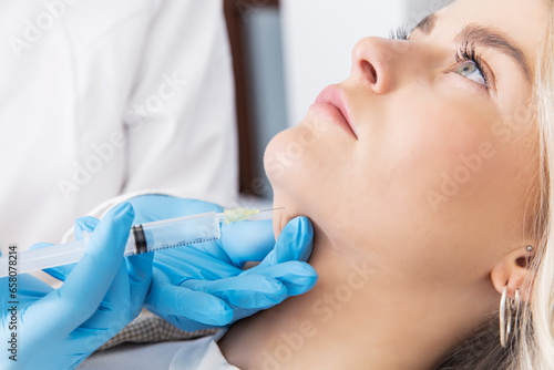 doctor with a syringe injecting patient with botox photo