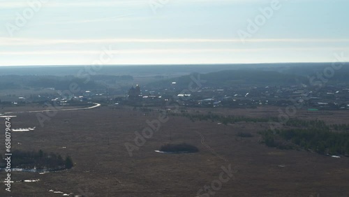 Aerial view of the village among fields and forests