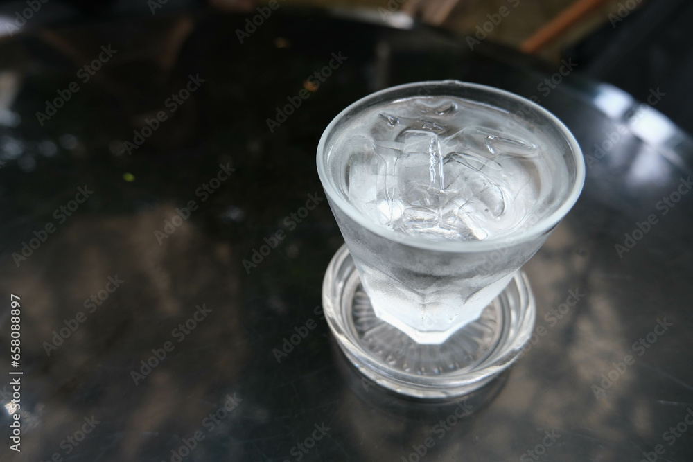 Glass of cold water with some ice on black table. Glass of cold water with some ice on black table.