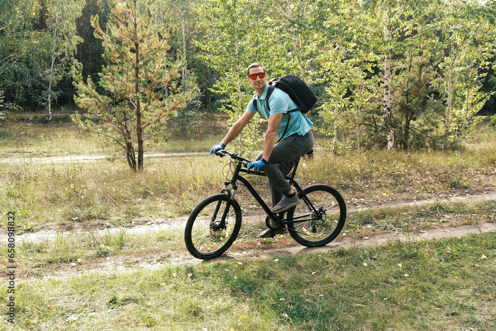 active lifestyle.A cyclist with a backpack rides through the autumn forest and looks away active lifestyle.A cyclist with a backpack rides through the autumn forest and looks away