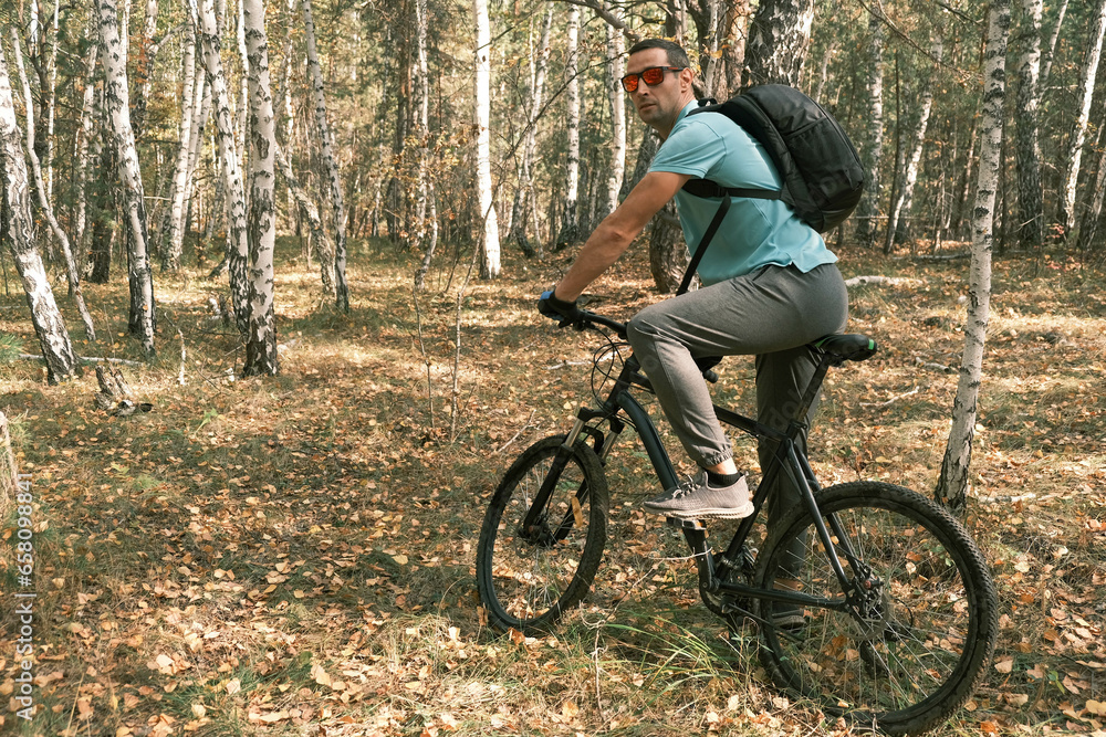 Fototapeta premium active lifestyle.A cyclist with a backpack is sitting on a bicycle in the autumn forest