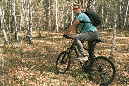  active lifestyle.A cyclist with a backpack is sitting on a bicycle in the autumn forest