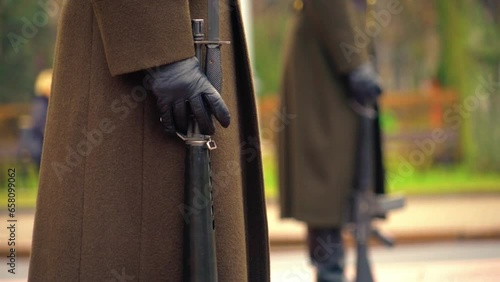 Close up of guards hand holding a black rifle during official ceremony photo